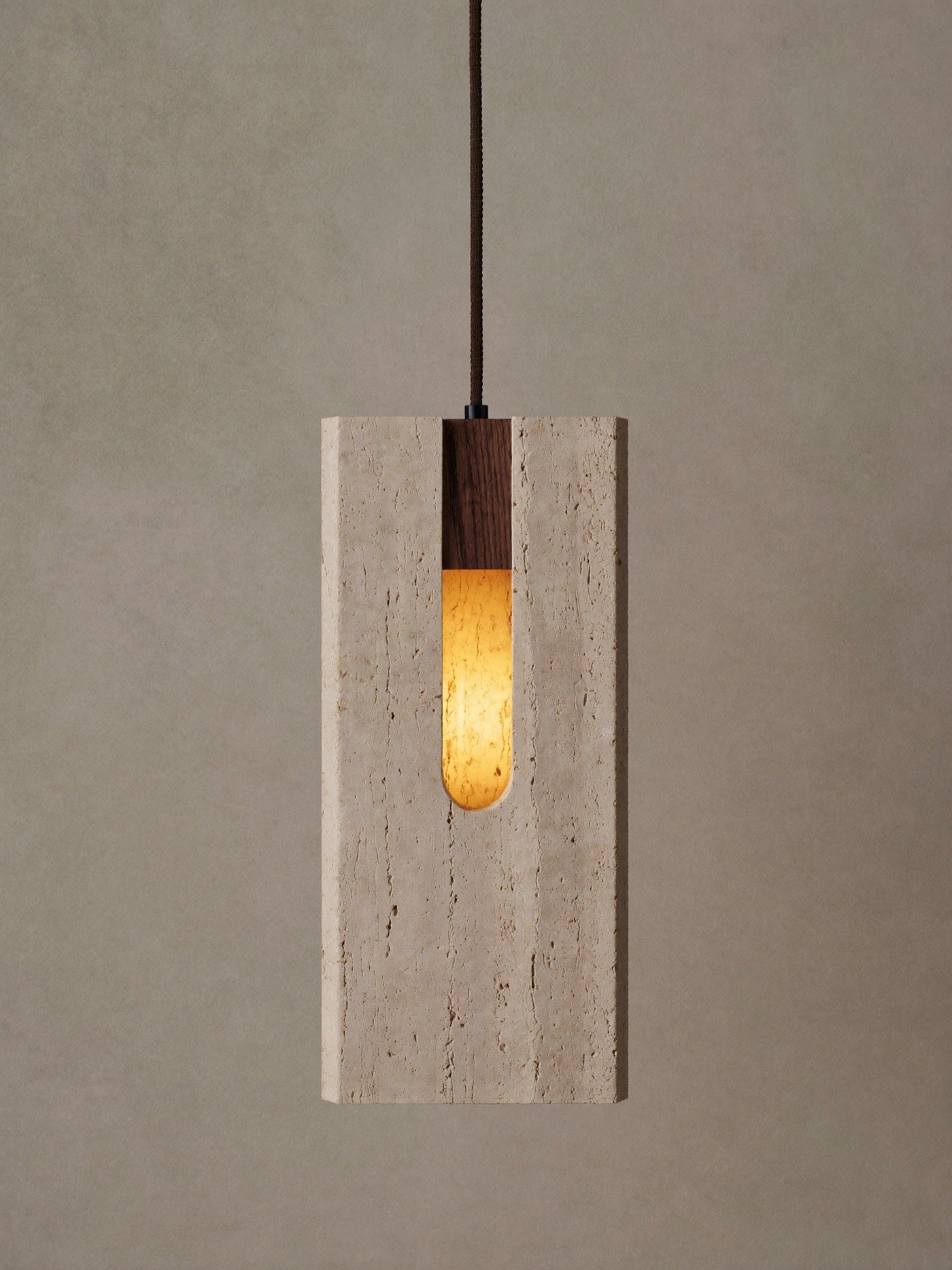 Close detail of a travertine pendant light with a walnut stem, lit from within