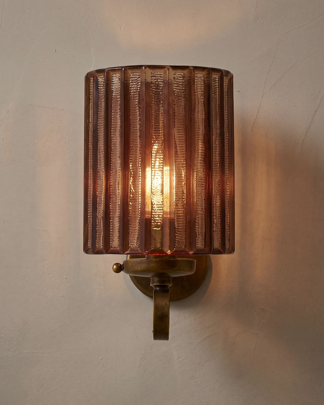 A fluted amber glass wall light on aged brass