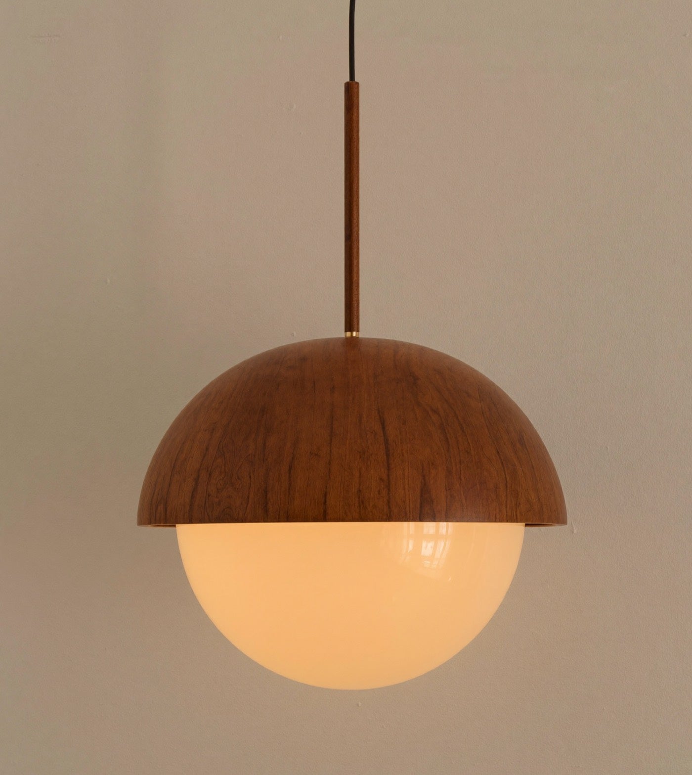 A walnut and opal glass pendant light
