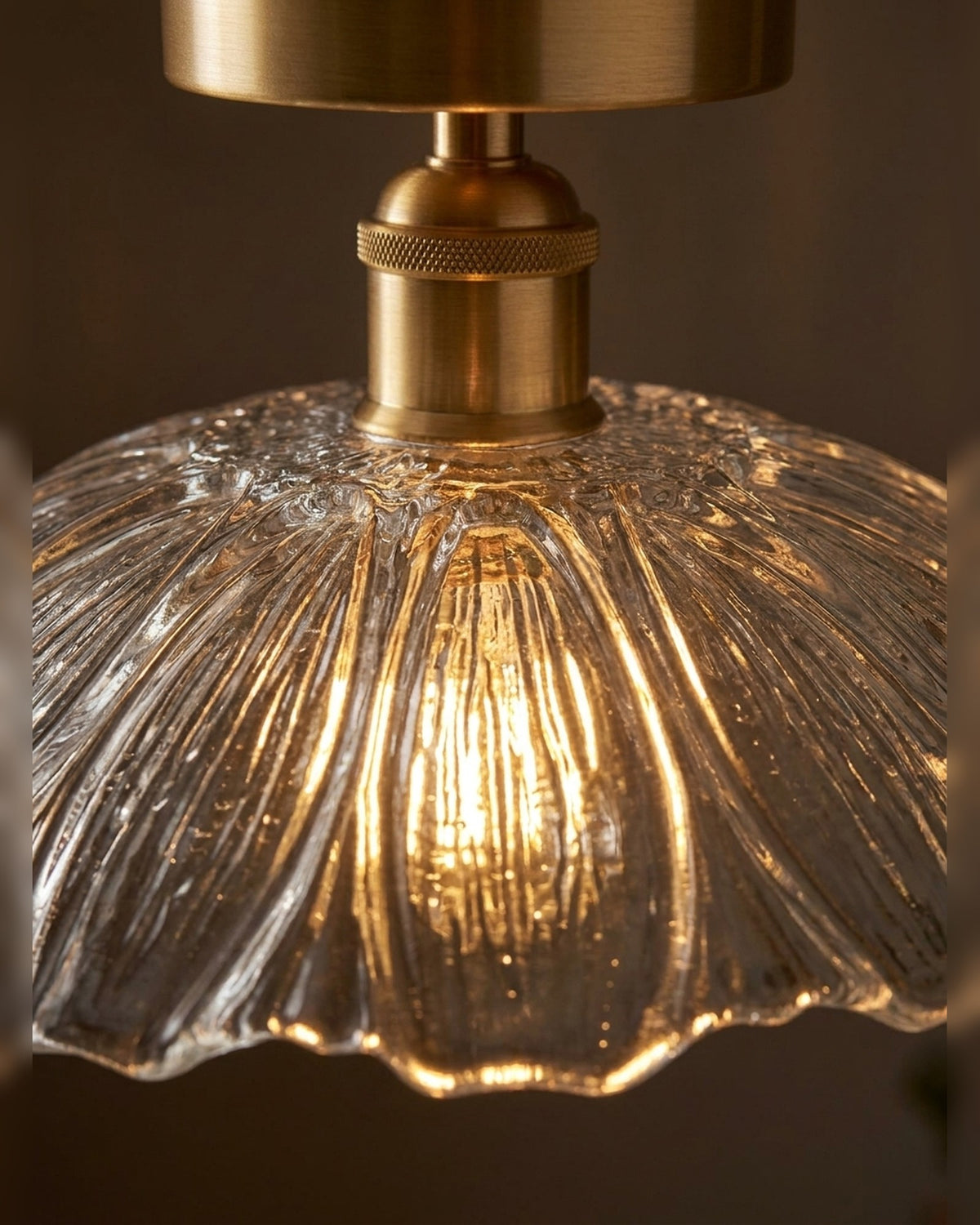 Macro of the fluted pressed glass and aged brass stem, lit warm