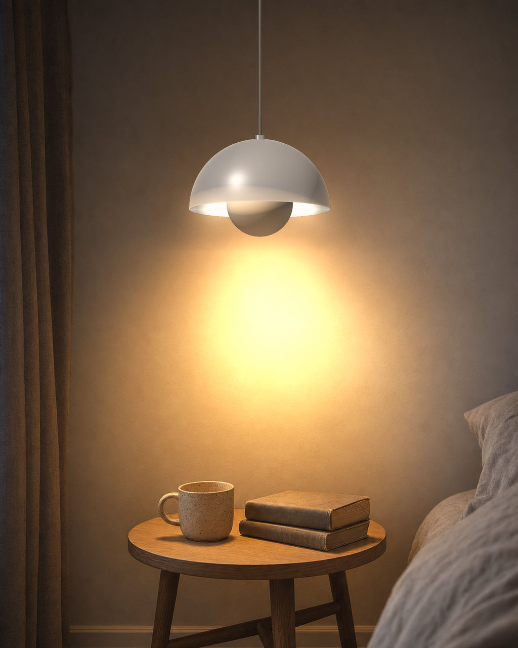 White iron dome pendant glowing over a bedside table at dusk