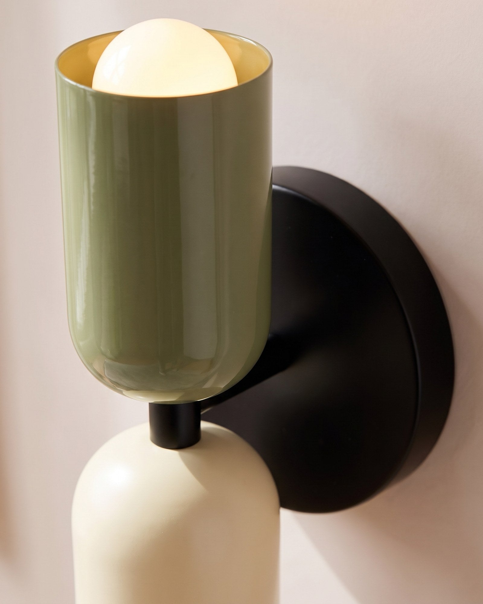 Macro of the enamelled green shade, black backplate and glowing opal globe bulb