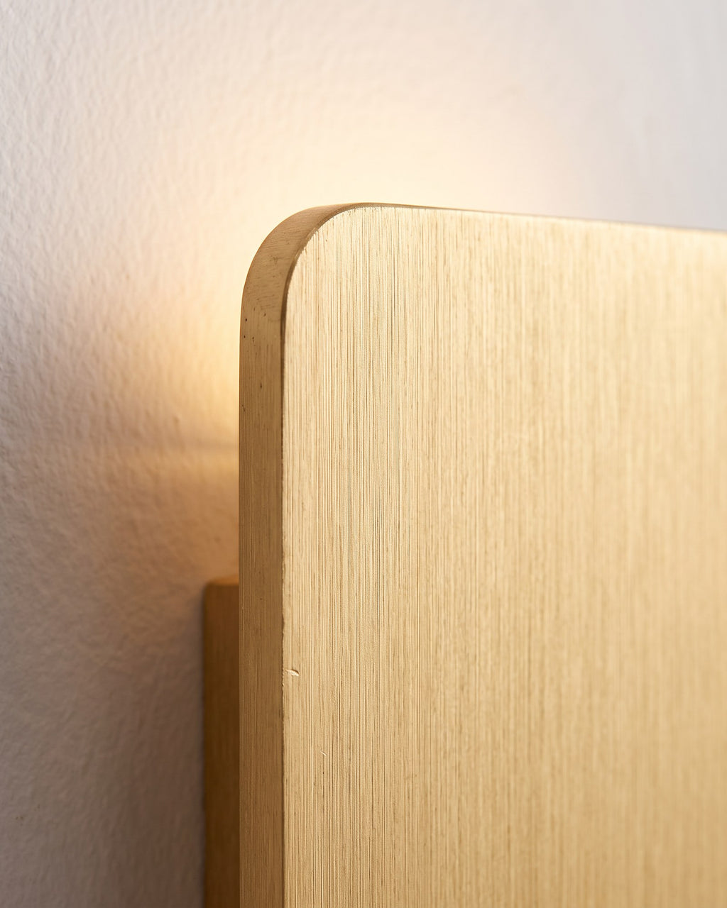 Macro of the Nova's brushed gold metal face and the warm LED glow at its edge