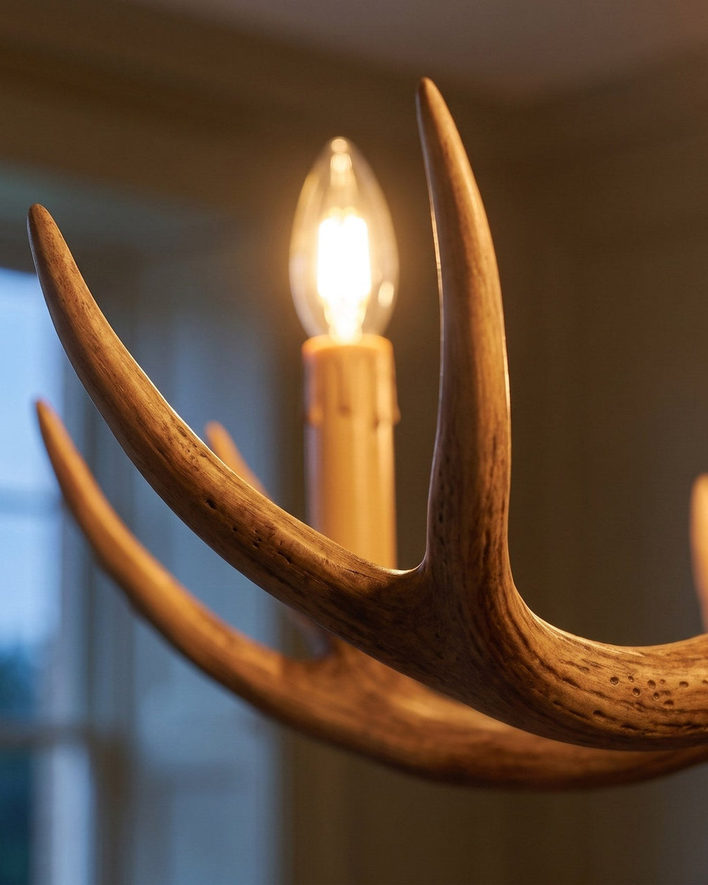 Macro of a cast antler — wood-effect grain lit by a warm candle bulb