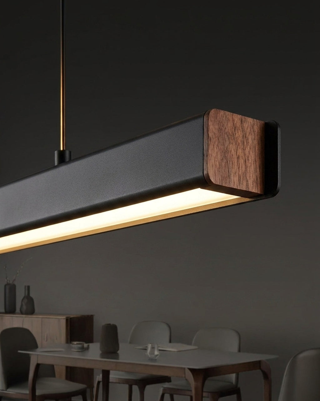 Macro of the Thala bar — matte black aluminium meeting the solid walnut end
