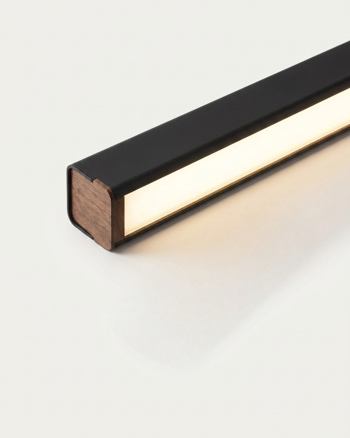 Thala linear LED pendant lit warm white on a cream surface