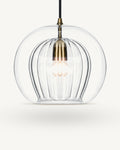 Zoey glass pendant light in Clear, a smooth outer glass globe over a ribbed inner shade, brass-finish lampholder on a black flex, shown against a plain light background.
