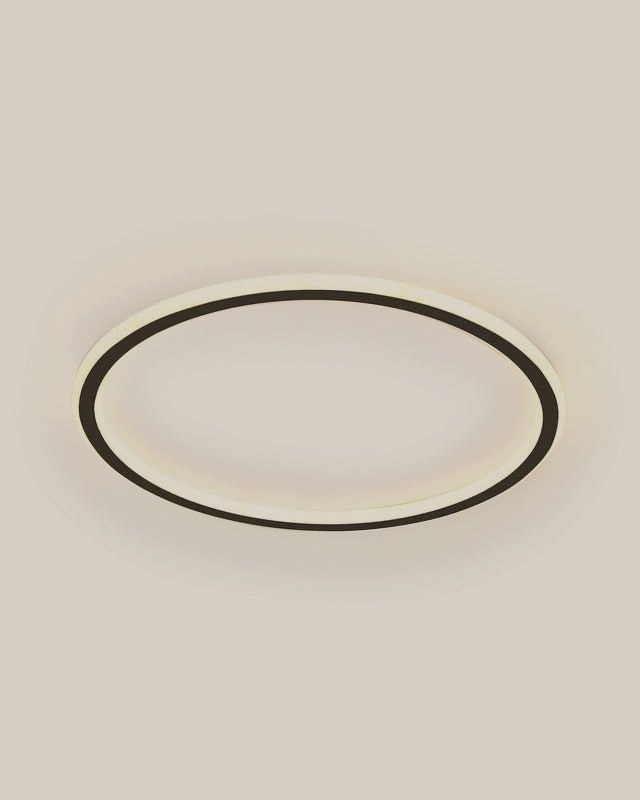 A slim black LED flush ceiling light glowing warmly
