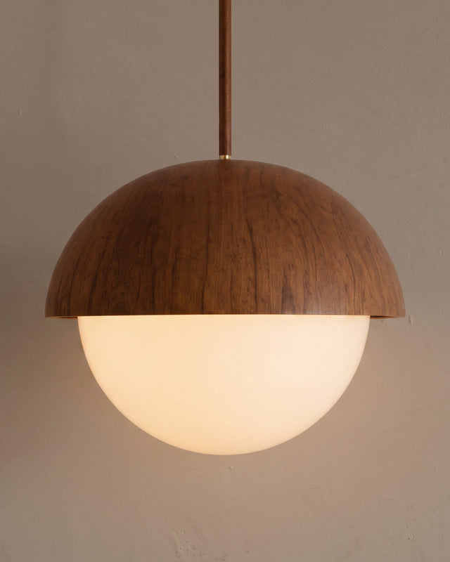 A wood-tone and opal glass pendant light